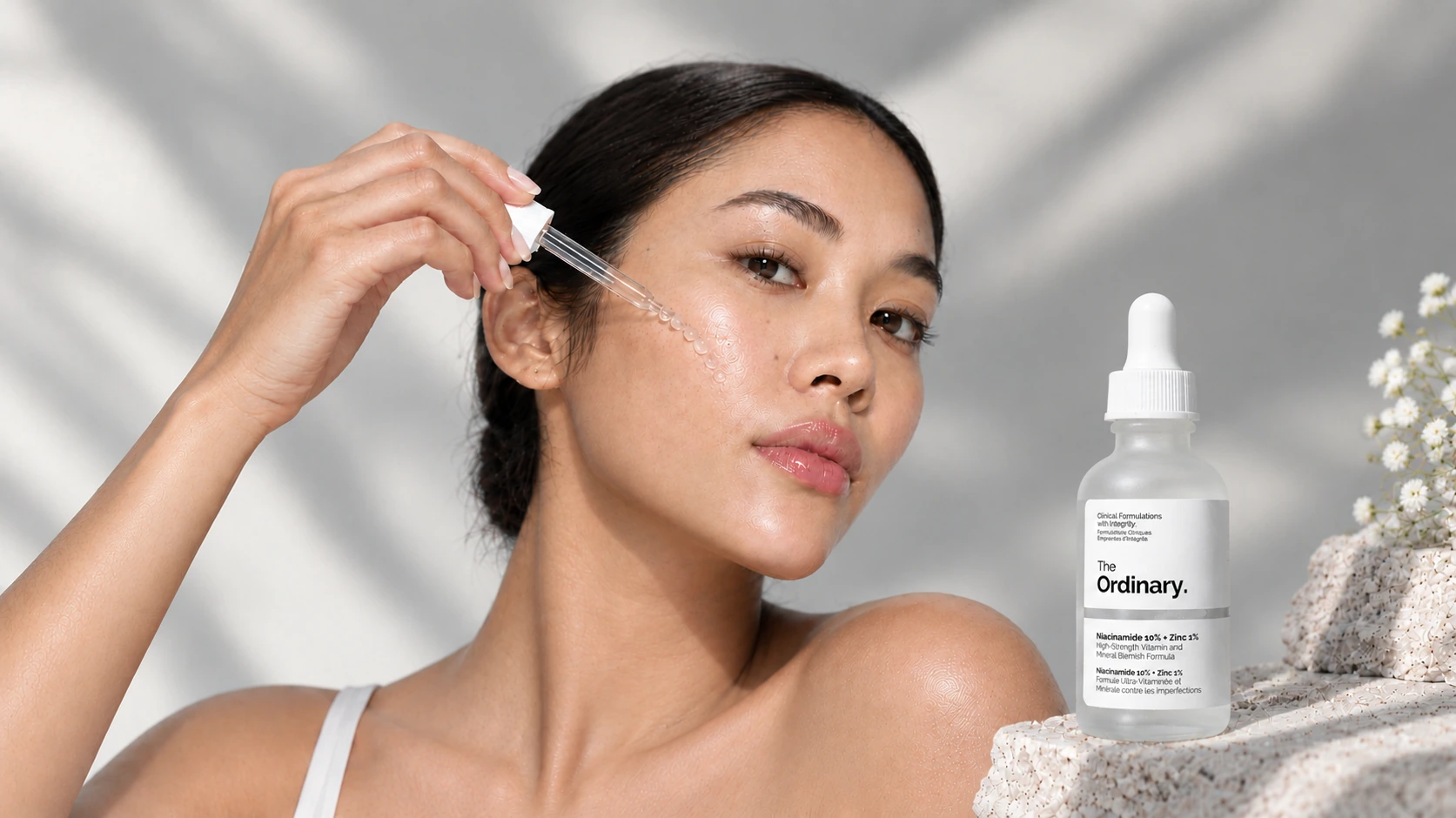 Woman applying Niacinamide 10% + Zinc 1% serum to her face