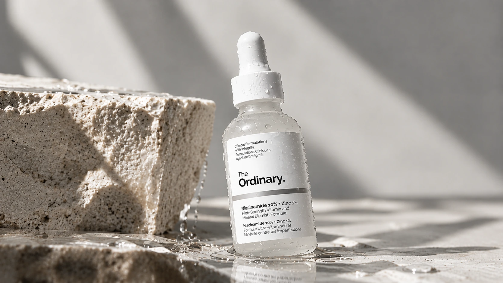 The Ordinary Niacinamide 10% + Zinc 1% serum displayed on a wet stone surface